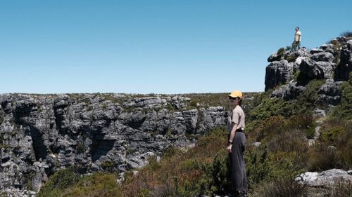 Free Two adults exploring rugged terrain on Table Mountain in Cape Town, surrounded by stunning natural landscapes. Stock Photo