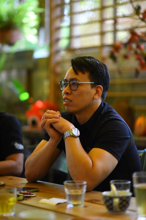 Free Casual scene of a man in glasses at a cafe, engaged in conversation. Stock Photo
