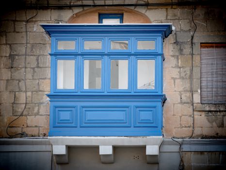 Captivating blue wooden balcony in Malta, showcasing traditional Mediterranean architecture.