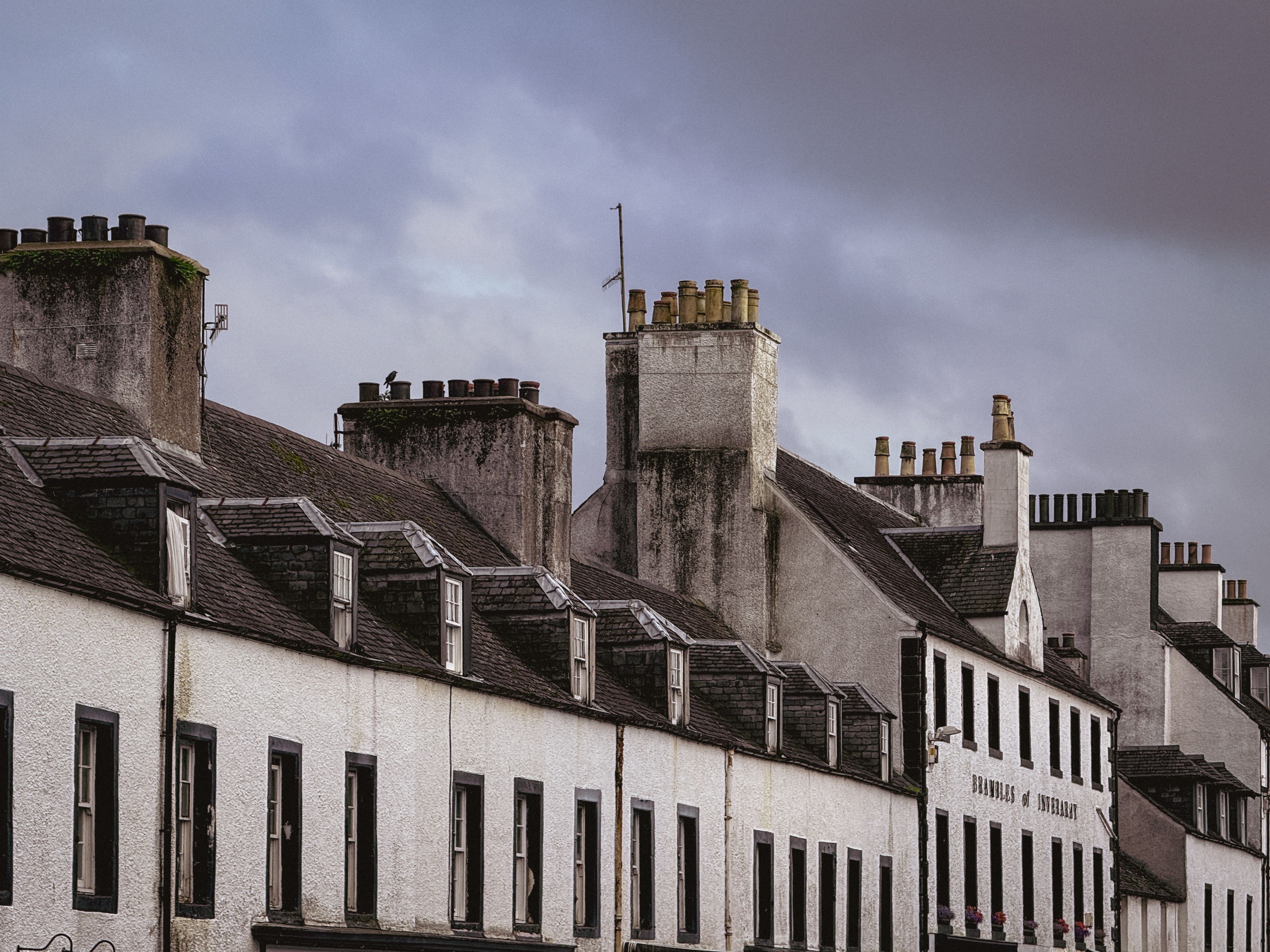 Historic Row Houses with Chimneys Under Moody Sky · Free Stock Photo