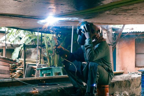 Free A welder at work outdoors in Dhaka, Bangladesh, showcasing skilled industrial labor in a vibrant setting. Stock Photo