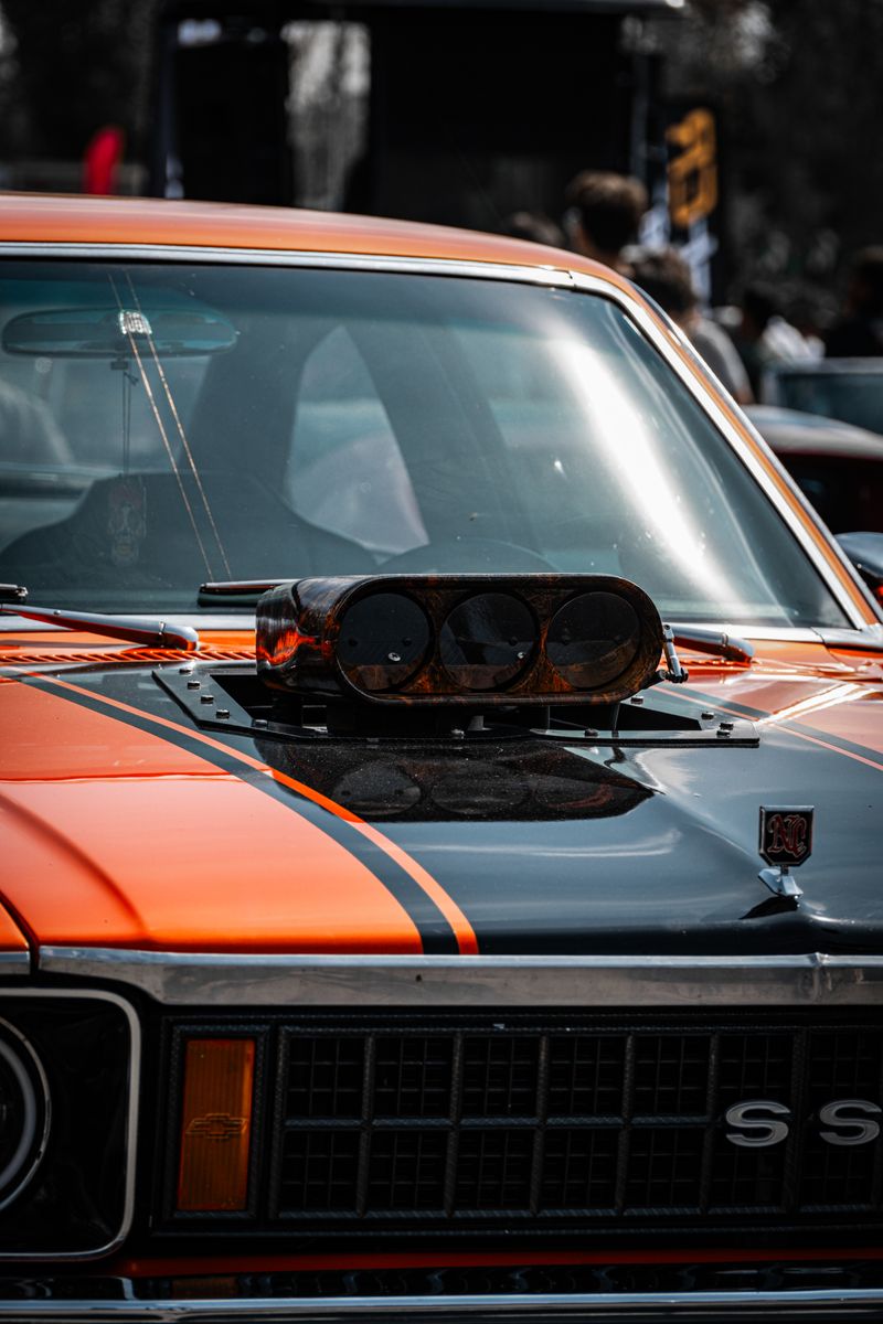 Close-up of a classic muscle car's supercharger at an auto show in Ankara, Türkiye.