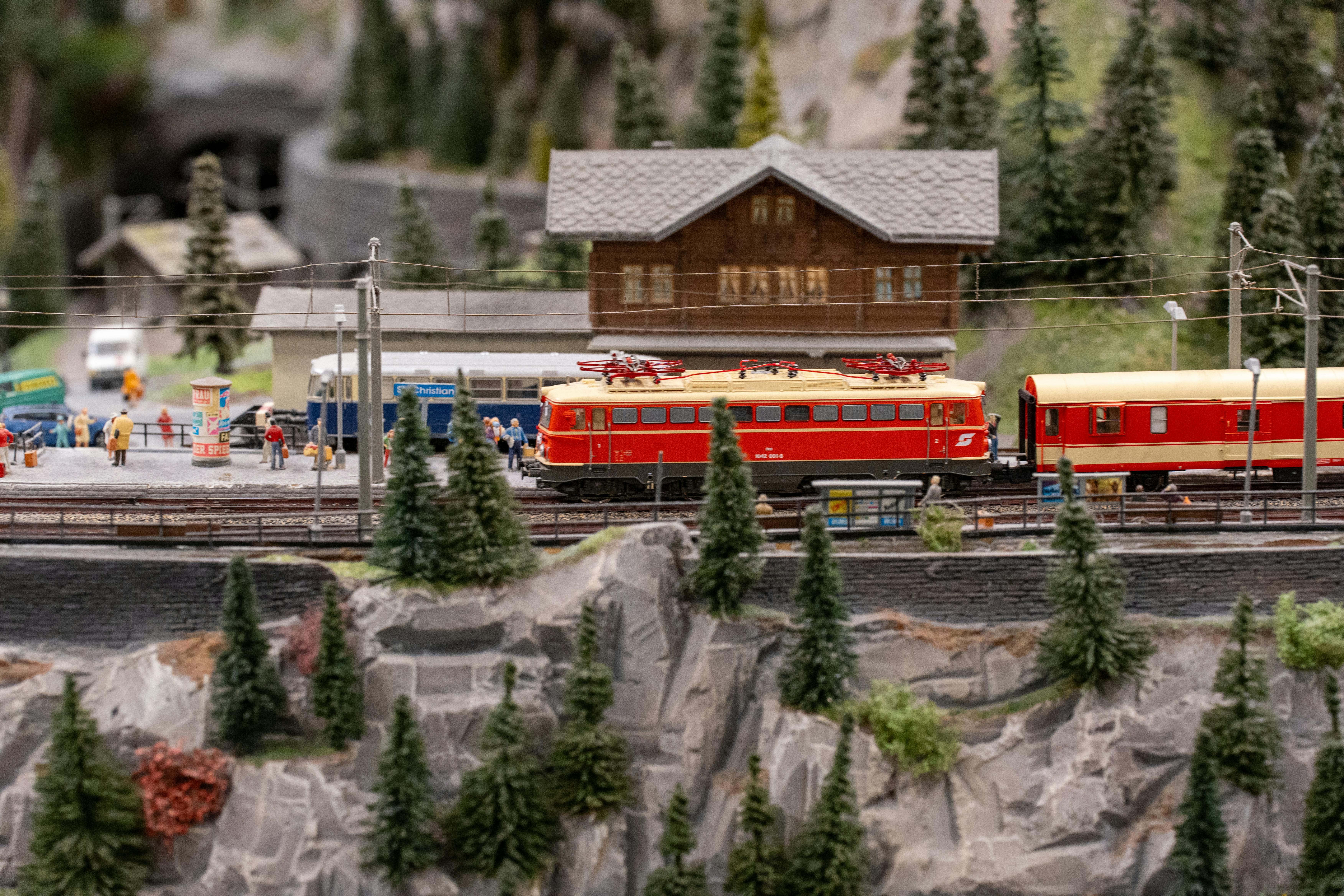 bezplatná Detailní miniaturní model horské vlakové stanice s historickým vlakem a drobnými figurkami. Základová fotografie