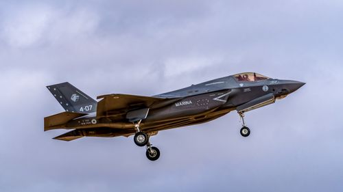 Free F-35 fighter jet soaring through a cloudy sky at Los Llanos Air Base, Spain. Stock Photo