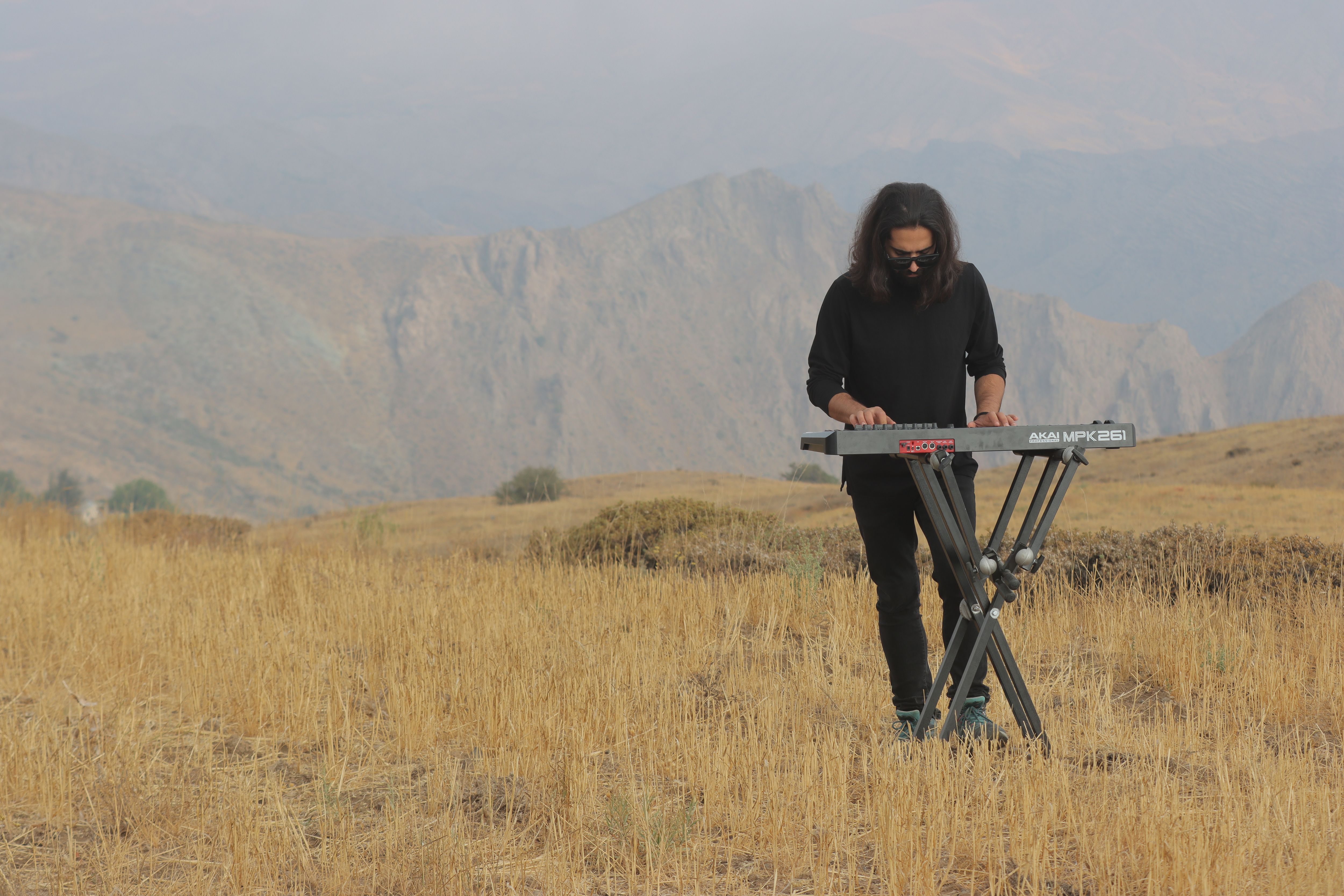 A musician performing on a keyboard in the scenic Qazvin mountains.