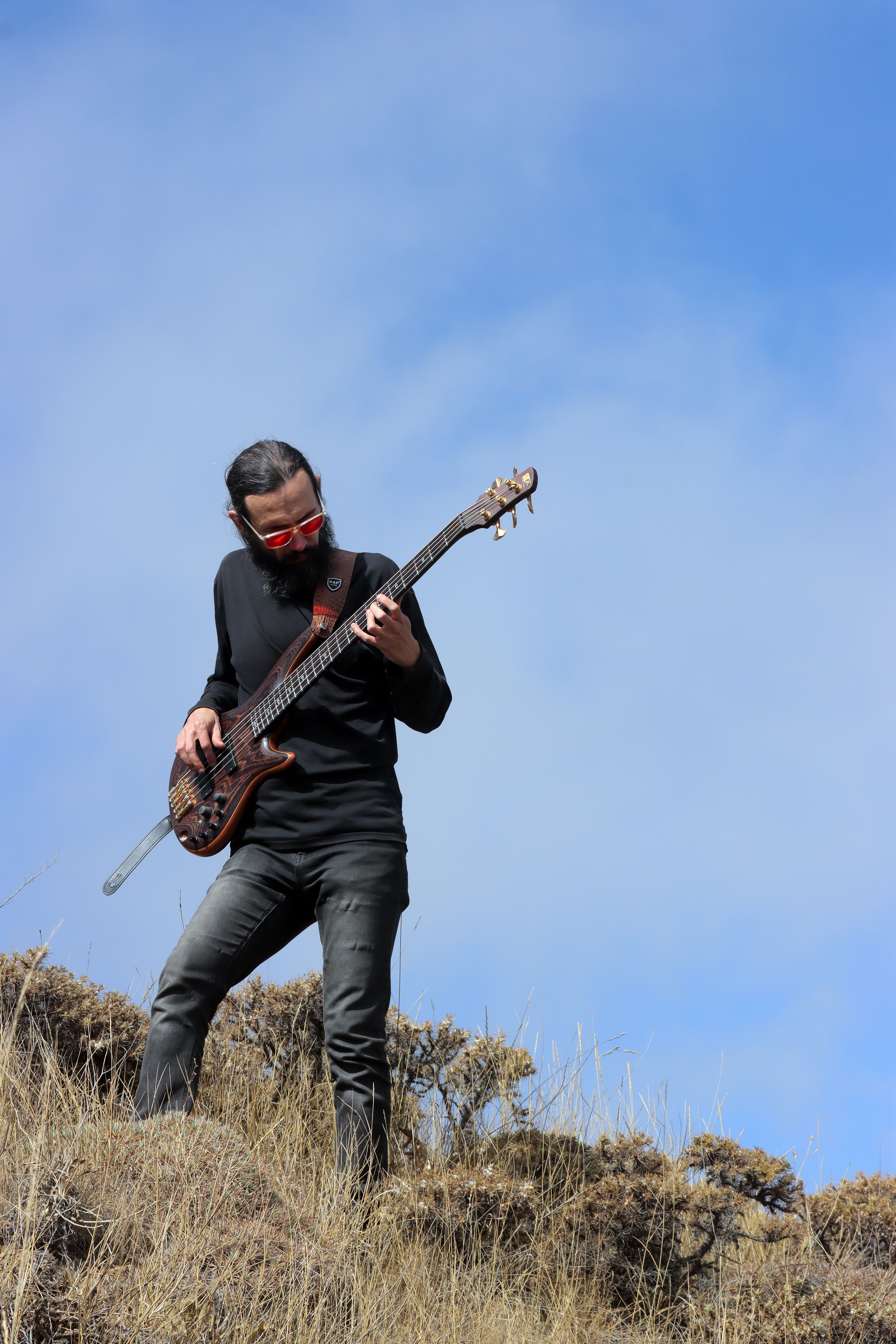 A musician playing the bass guitar outdoors in Qazvin Province, Iran.