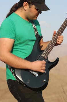 A young male guitarist plays an electric guitar in the picturesque outdoors of Qazvin Province, Iran.