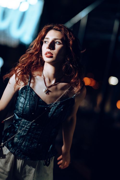 Free Stunning portrait of a woman with red hair in night street setting. Stock Photo