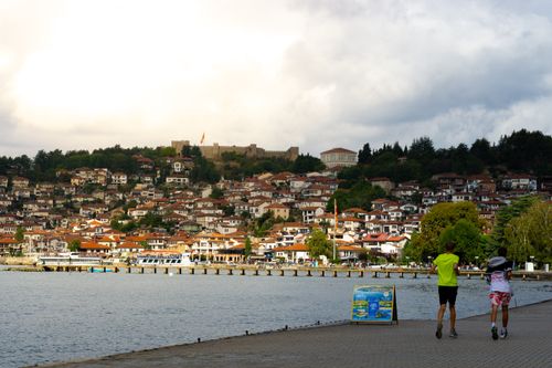 Free Tourists enjoy a peaceful walk along the waterfront in Ohrid, North Macedonia. Stock Photo