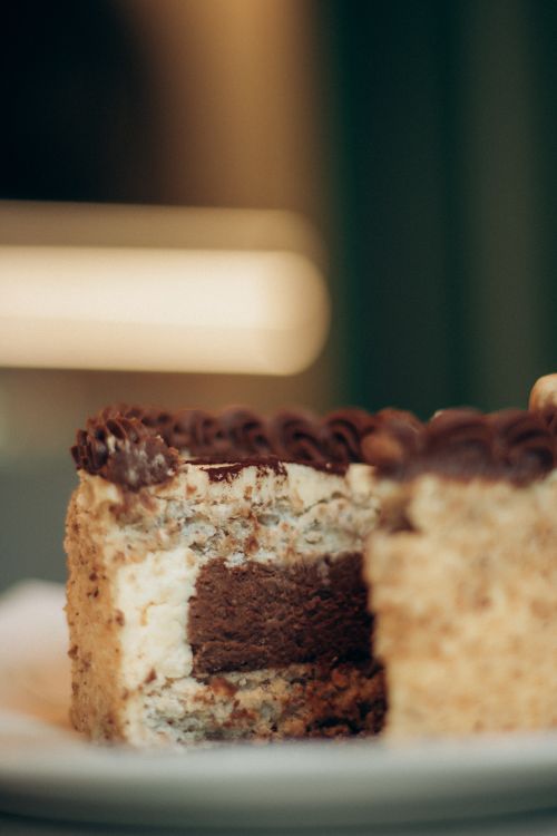 Free Delicious chocolate layer cake with rich frosting on a plate, perfect for dessert lovers. Stock Photo