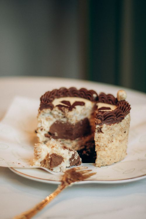 Free A tempting slice of chocolate cake with rich cream filling and ornate frosting. Stock Photo