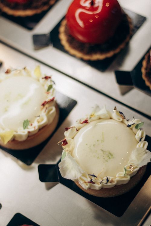 Free Close-up of gourmet tarts with decorative toppings in a bakery setting, ideal for culinary enthusiasts. Stock Photo