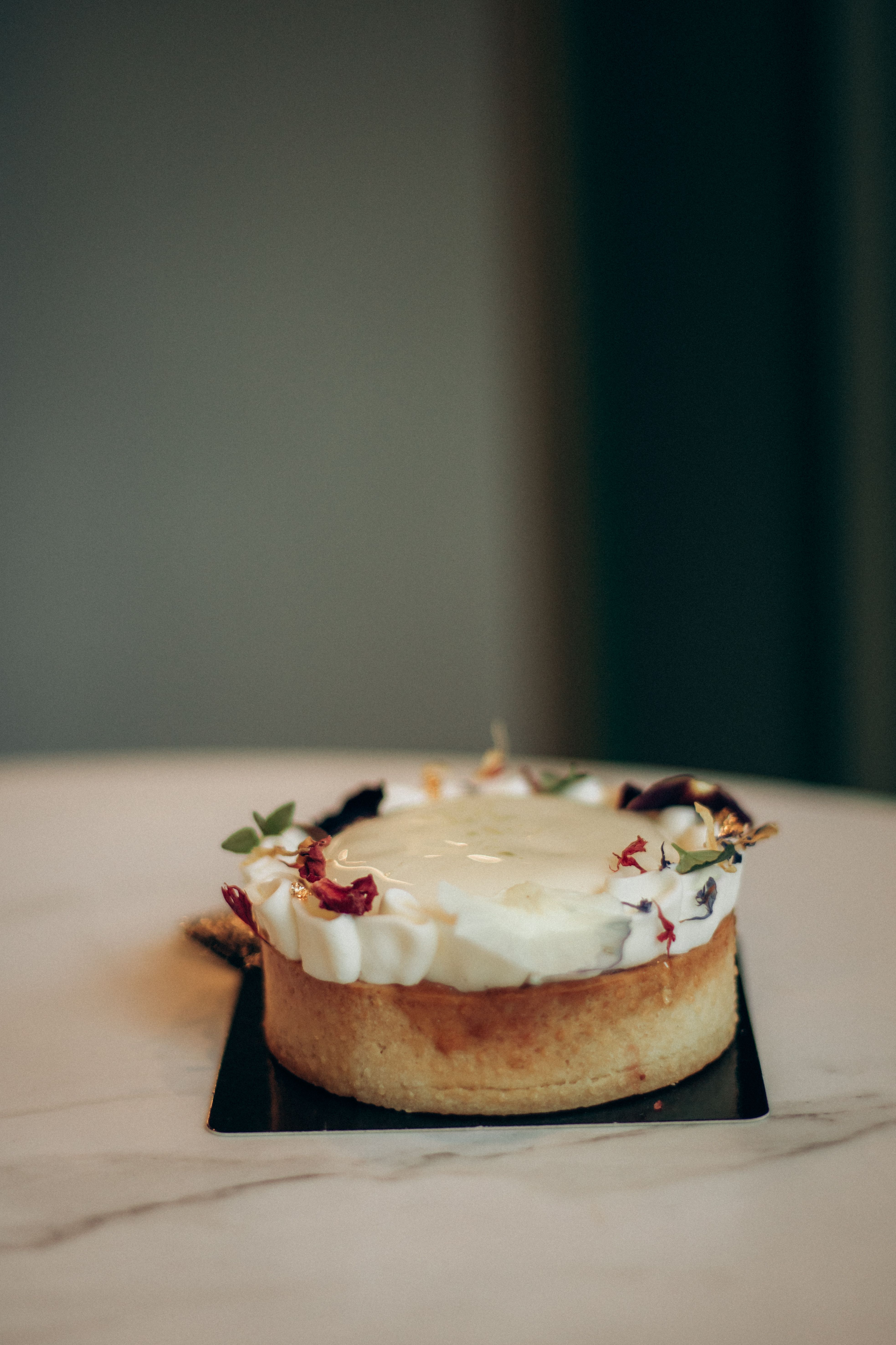 Delicate cream cake topped with edible flowers, perfect for elegant events.