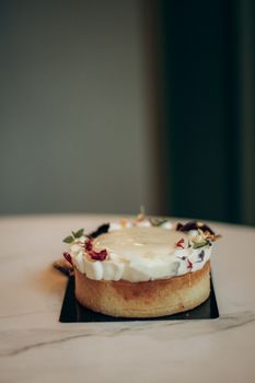 Delicate cream cake topped with edible flowers, perfect for elegant events.