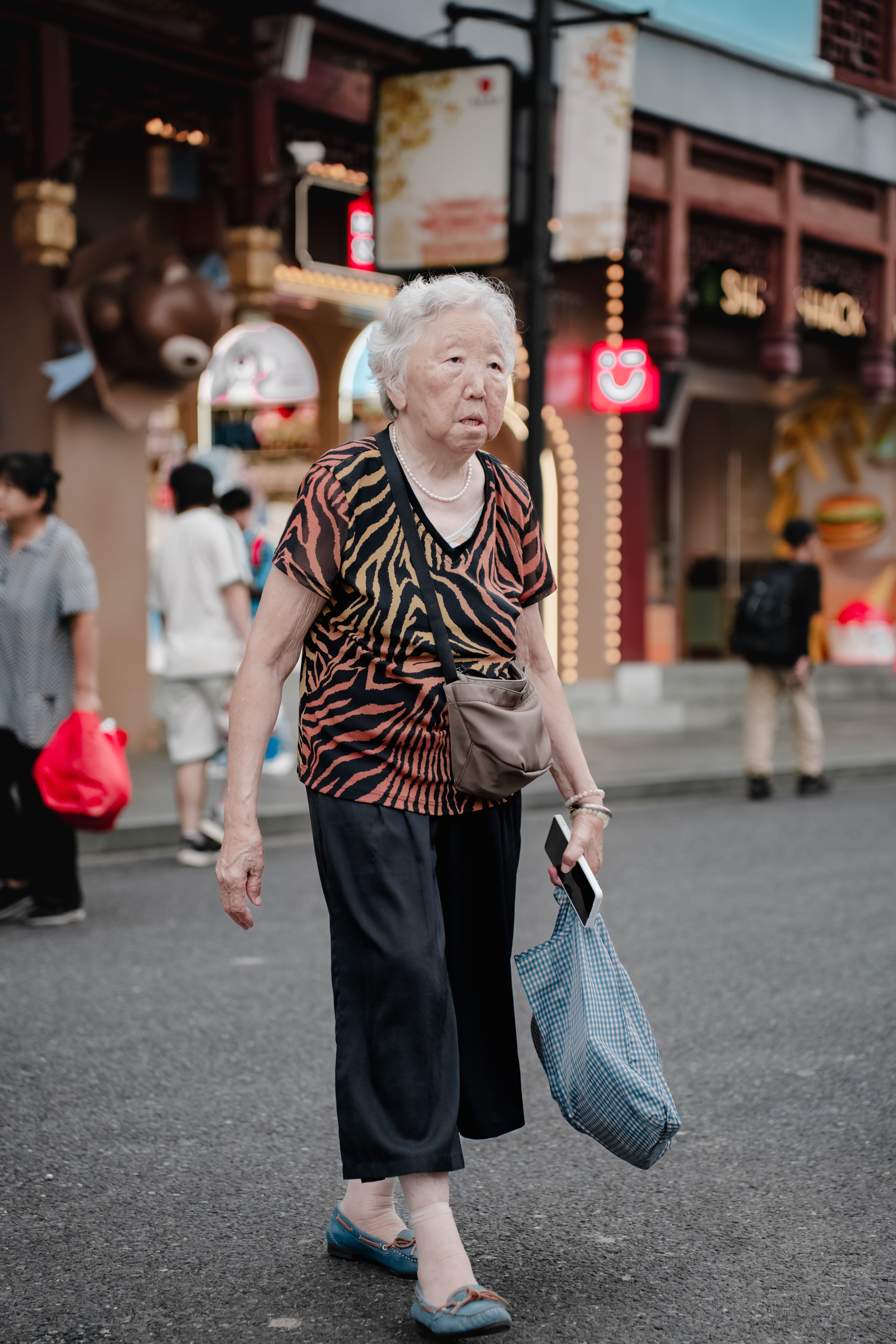 Elderly Woman Walking on a Busy City Street · Free Stock Photo
