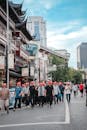 Group Touring Traditional Chinese Street with Red Hats