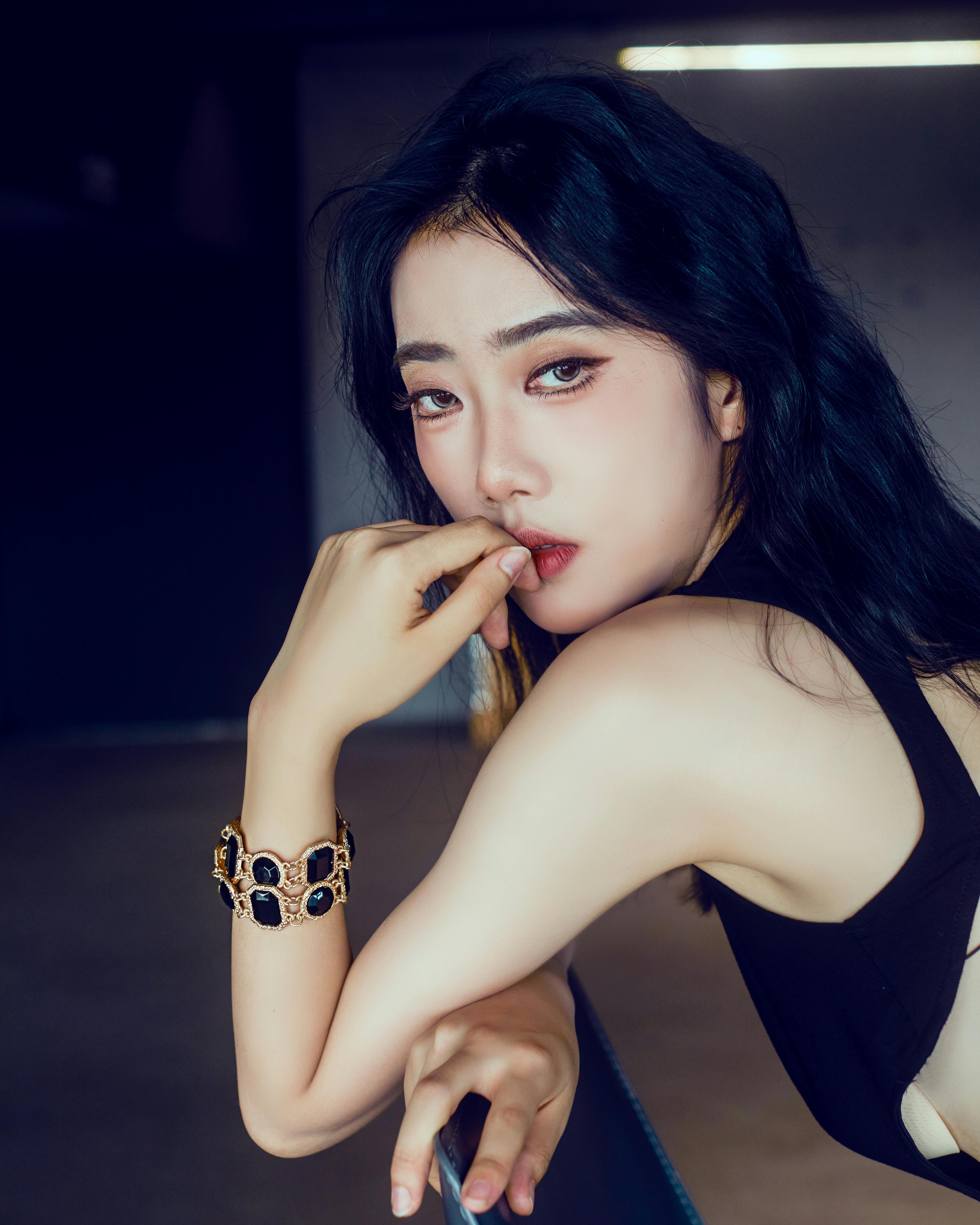 Stylish woman with black hair and jewelry posing confidently indoors. High fashion and elegance.