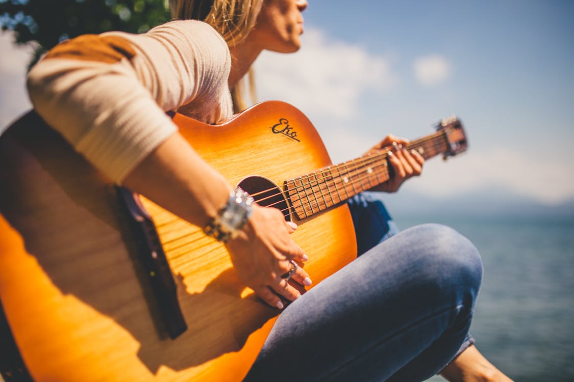 Free Woman Sitting Holding Guitar Stock Photo
