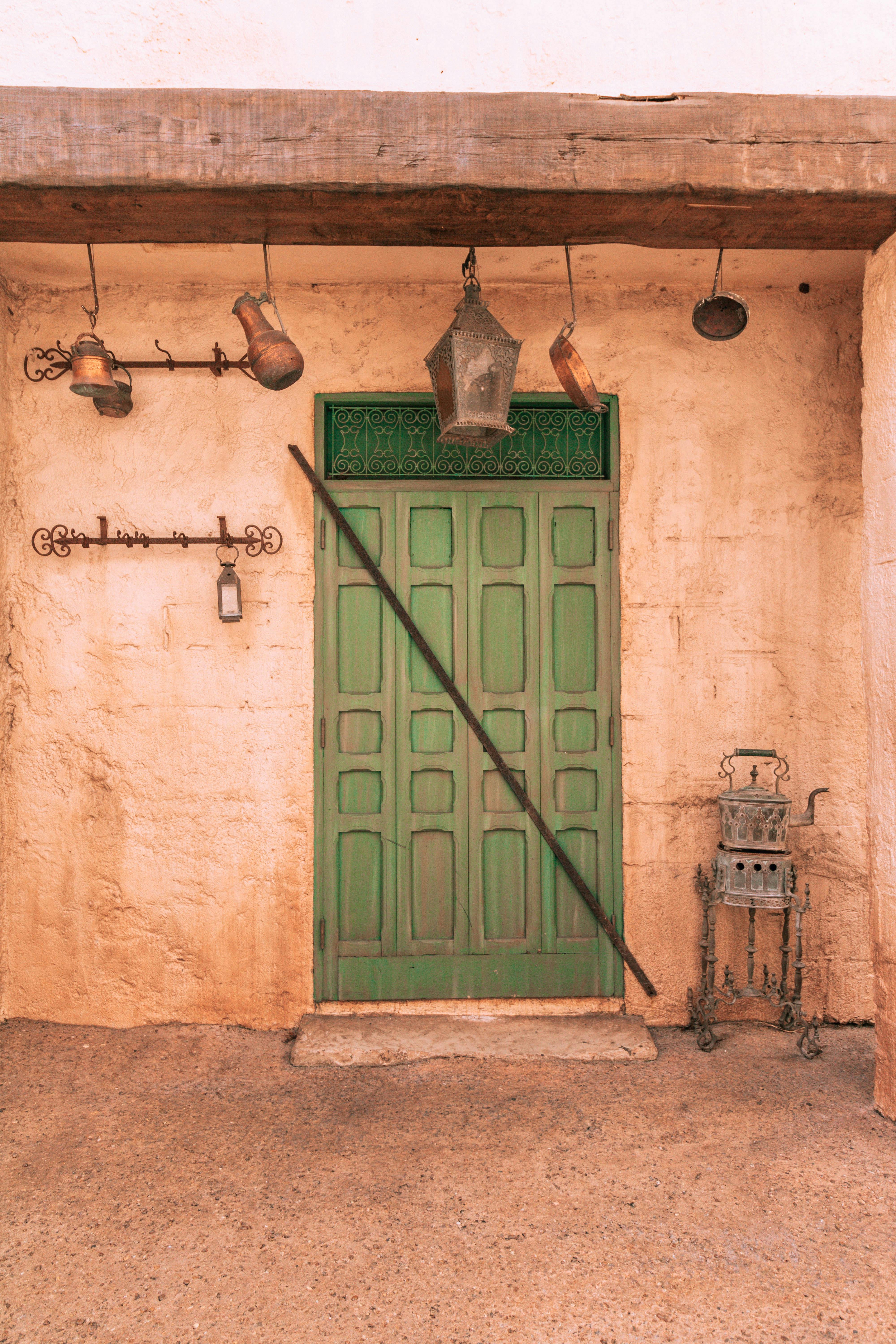 Rustic scene of a green door with vintage lanterns in Epcot, Florida.
