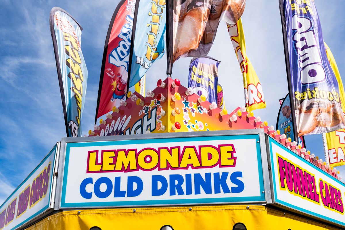 Vibrant vintage carnival food stand serving fresh-squeezed lemonade