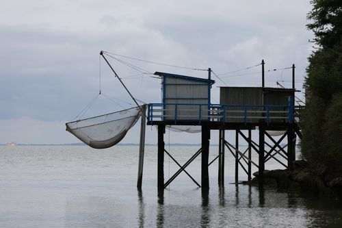Free A serene view of a fishing hut with net over calm waters, capturing coastal life. Stock Photo