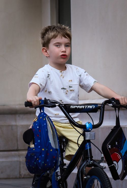 Free A young boy riding a bike with a playful expression in Dubai. Stock Photo