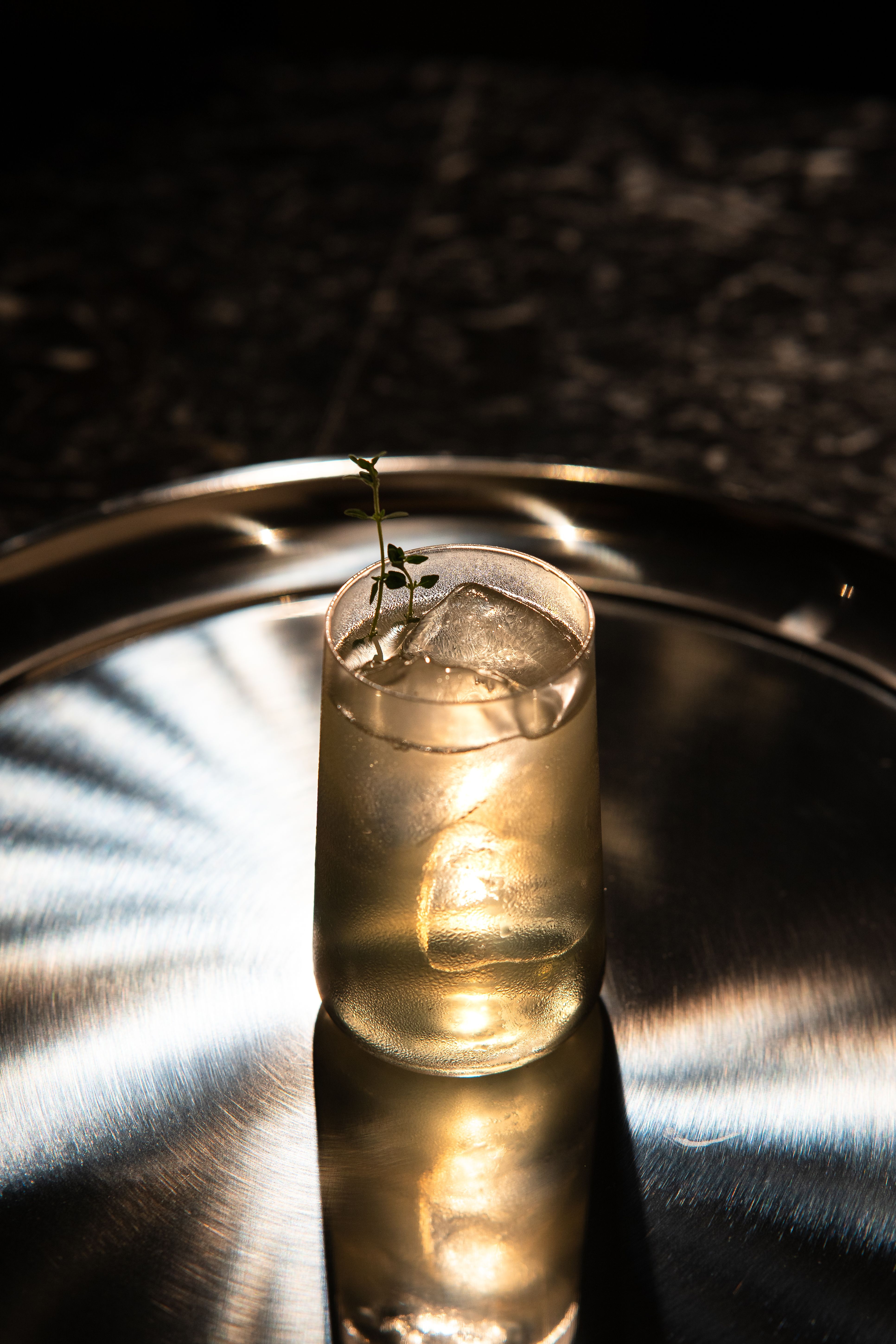 Elegant cocktail served in a Tokyo bar, beautifully lit on a reflective tray, creating a sophisticated ambiance.
