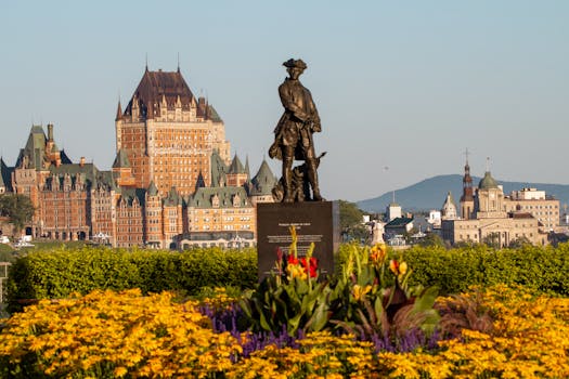 Scenic view of Château Frontenac with a statue in the foreground, Quebec City, during a sunny day.