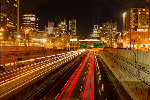 Dynamic long exposure of Montreal highway at night showing vibrant city lights and traffic trails.