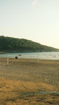 A tranquil beach scene with a volleyball net and soft sunset lighting, perfect for relaxation themes.
