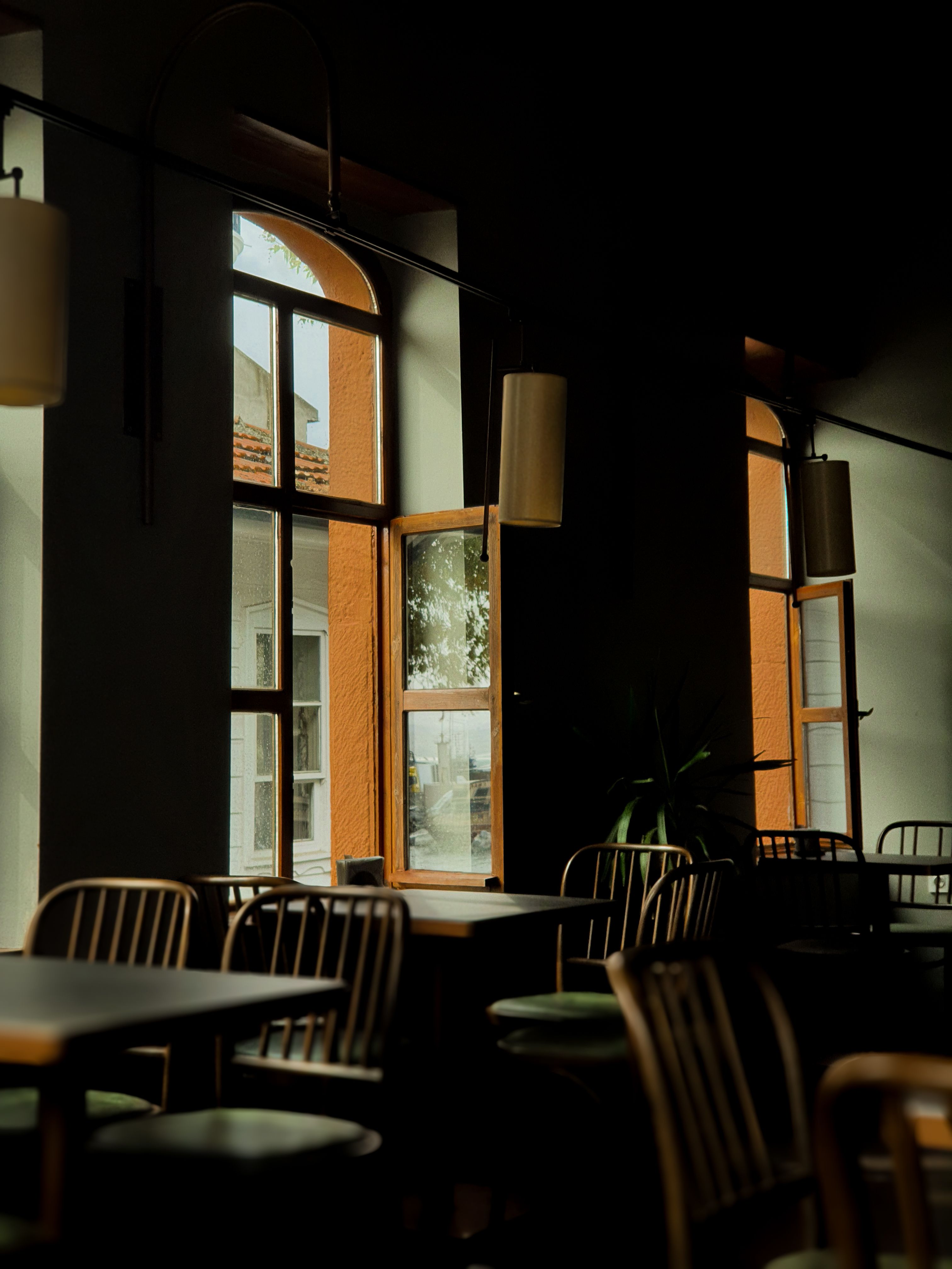 Warm, inviting cafe interior with natural sunlight streaming through large windows.