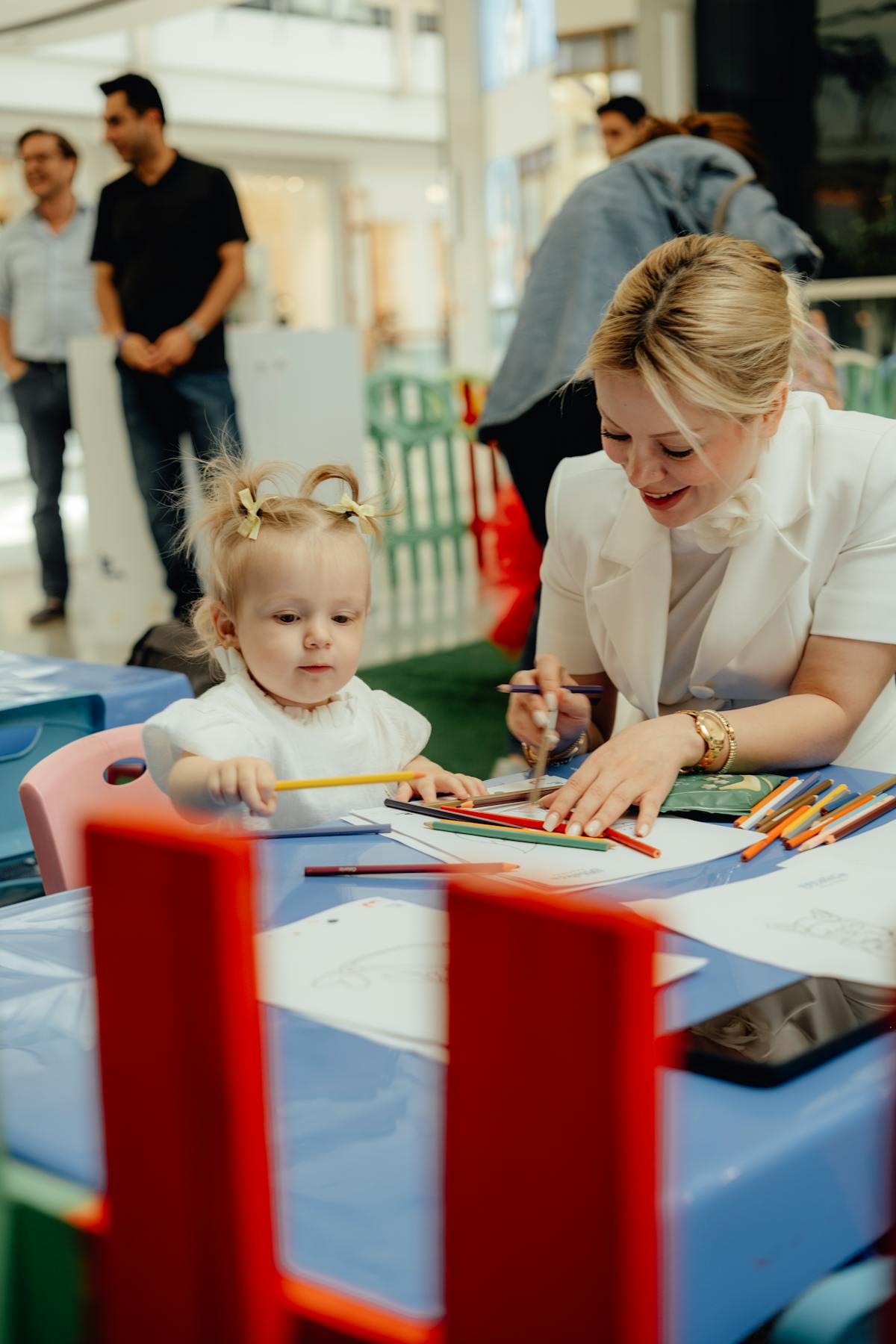Adulto e bambino intenti a disegnare insieme con colori e fogli