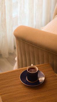 A warm living room setting featuring a coffee cup on a table, perfect for relaxation.