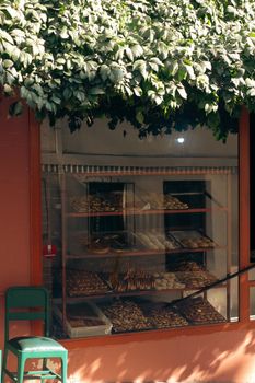 Inviting bakery storefront with assorted fresh pastries behind the window. Perfect for a street food presentation.