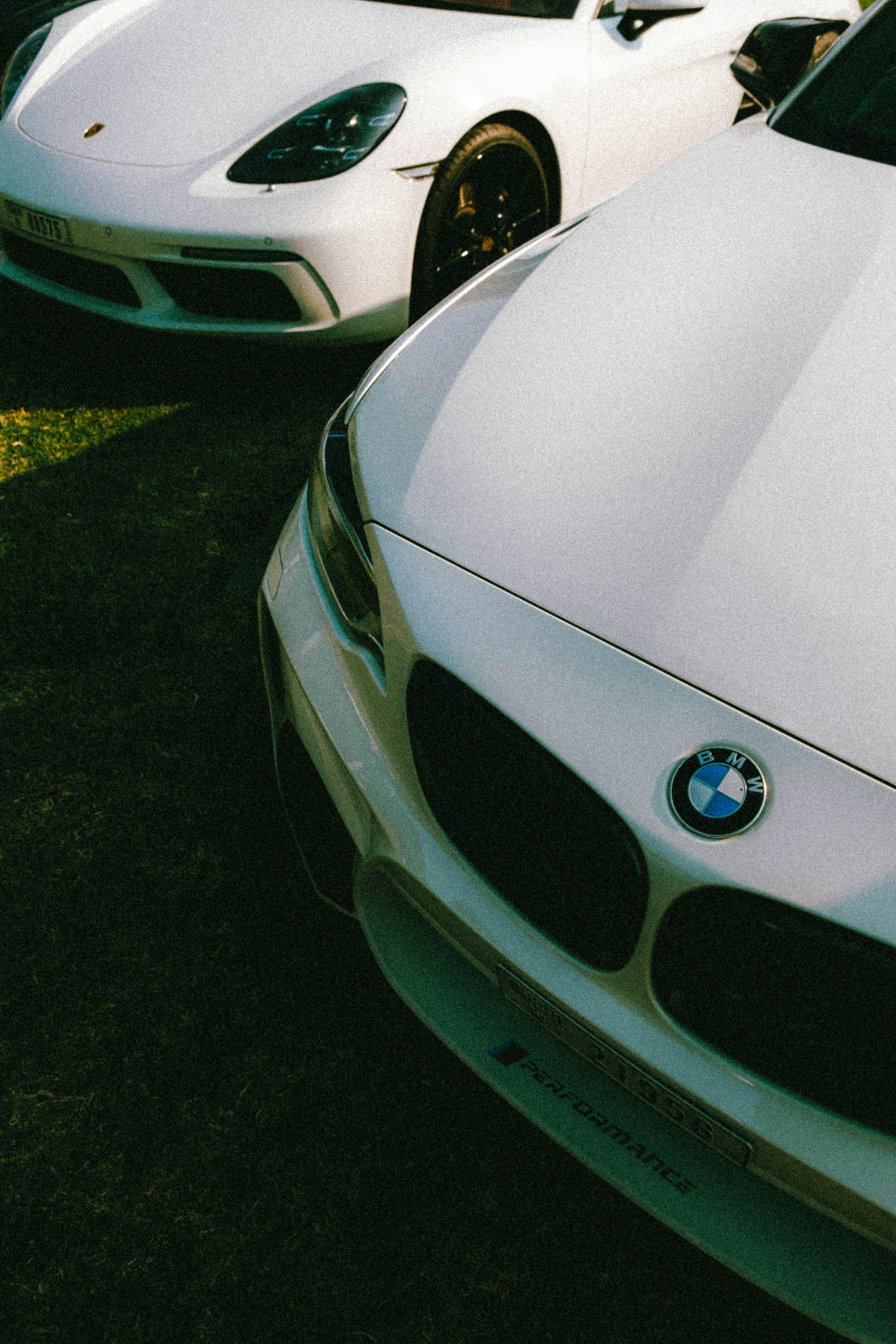 Close-up of luxury white cars under Dubai sun, highlighting opulence.