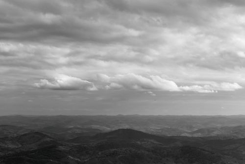 Free Serene clouds over the rolling hills of Minas Gerais, captured in black and white. Stock Photo