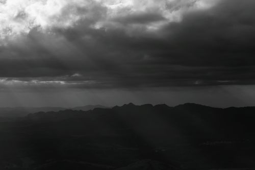 Free Black and white landscape of dramatic clouds casting shadows over mountains in Minas Gerais, Brazil. Stock Photo