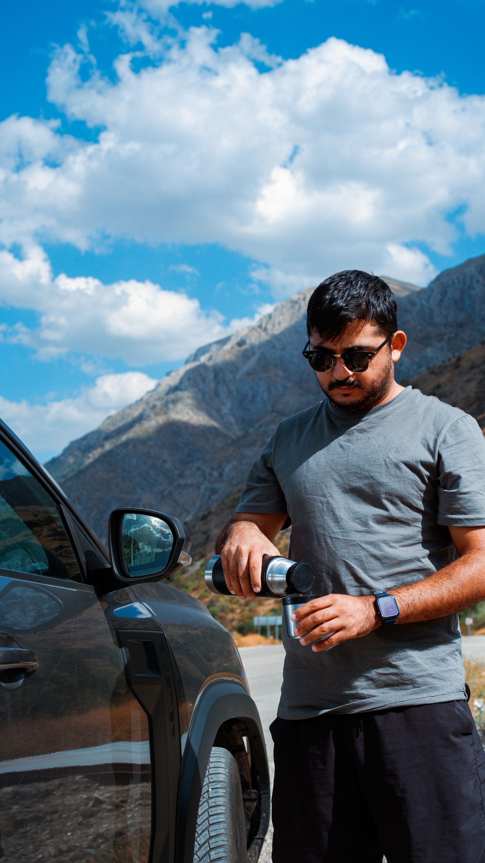 Traveler enjoying coffee on a mountain road trip, similar to loved coffee moments on the Ha Giang Loop