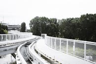 市区内，树木和建筑物环绕之中，铺设着带有现代栏杆的弯曲铁轨