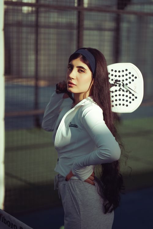 Free Middle Eastern woman with paddle racket on an outdoor court, ready to play. Stock Photo
