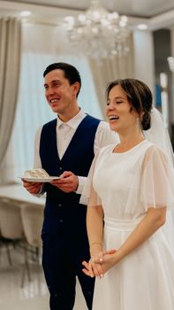 Happy bride and groom smiling in elegant indoor wedding setting, conveying joy and love.