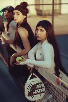 Group of young women enjoying paddle tennis on an outdoor court in Baghdad.