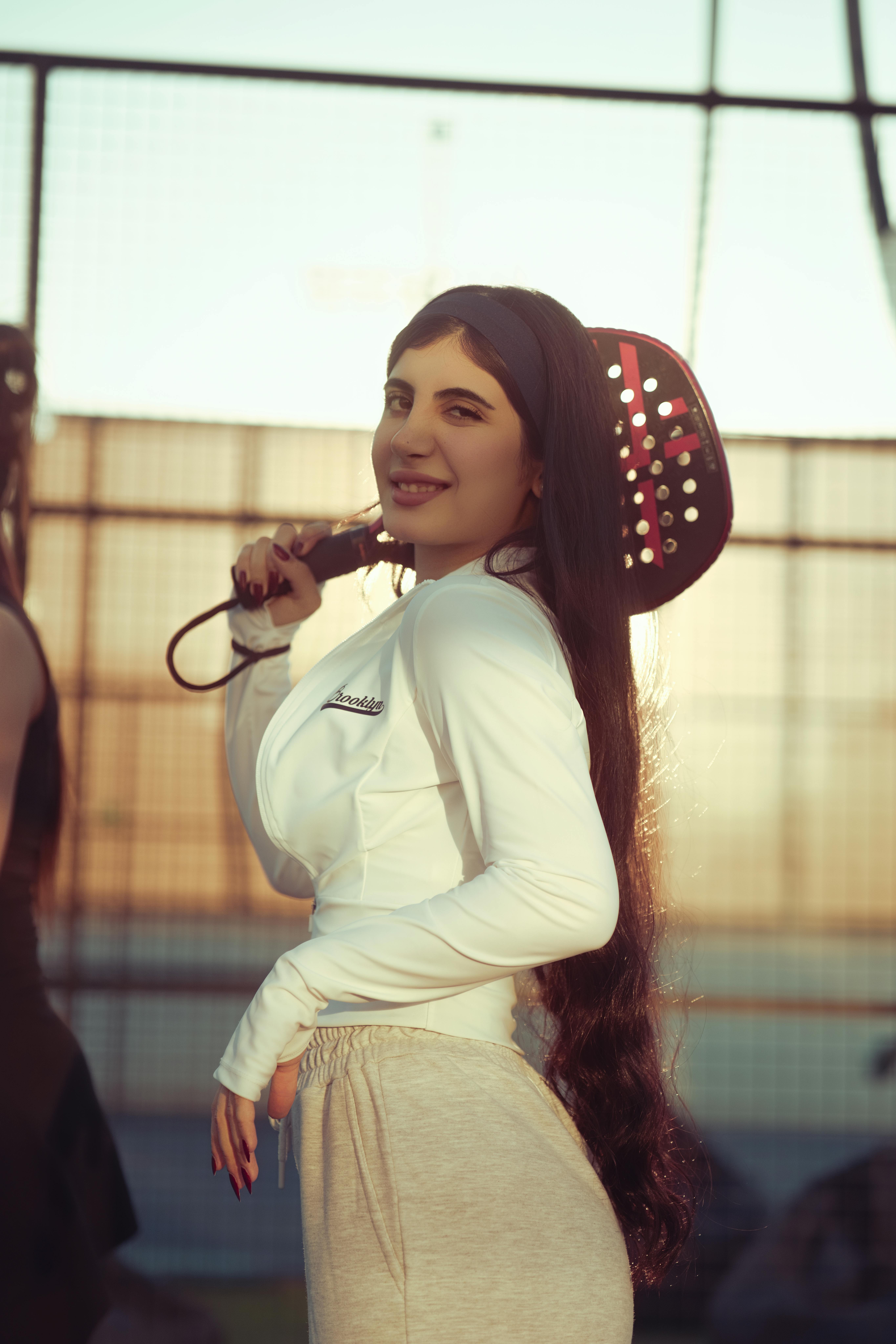 Gratis Una giovane donna si gode una partita di padel al tramonto a Baghdad, Iraq. Foto a disposizione