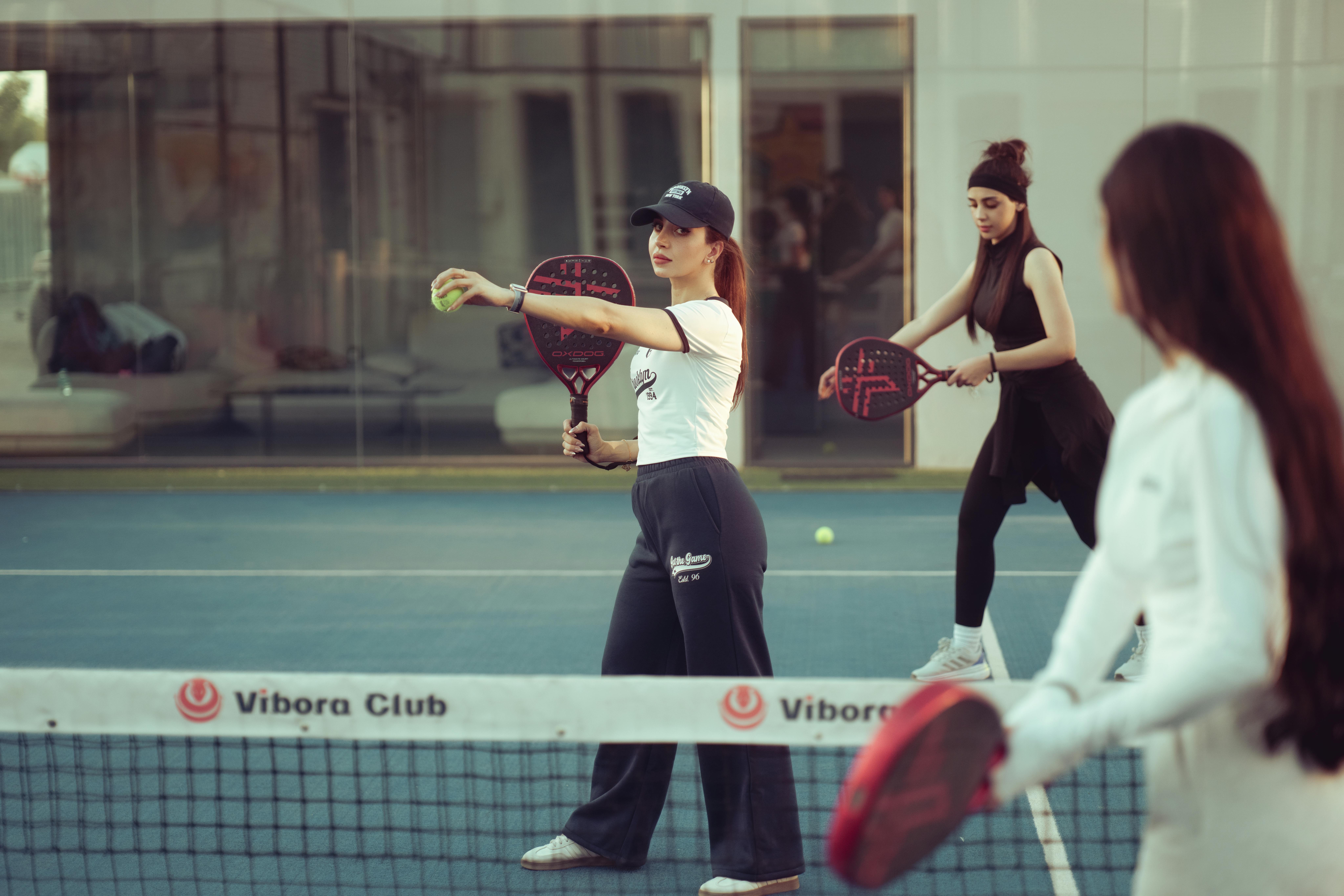 Dynamic scene of women playing padel tennis at Vibora Club in Baghdad, Iraq.