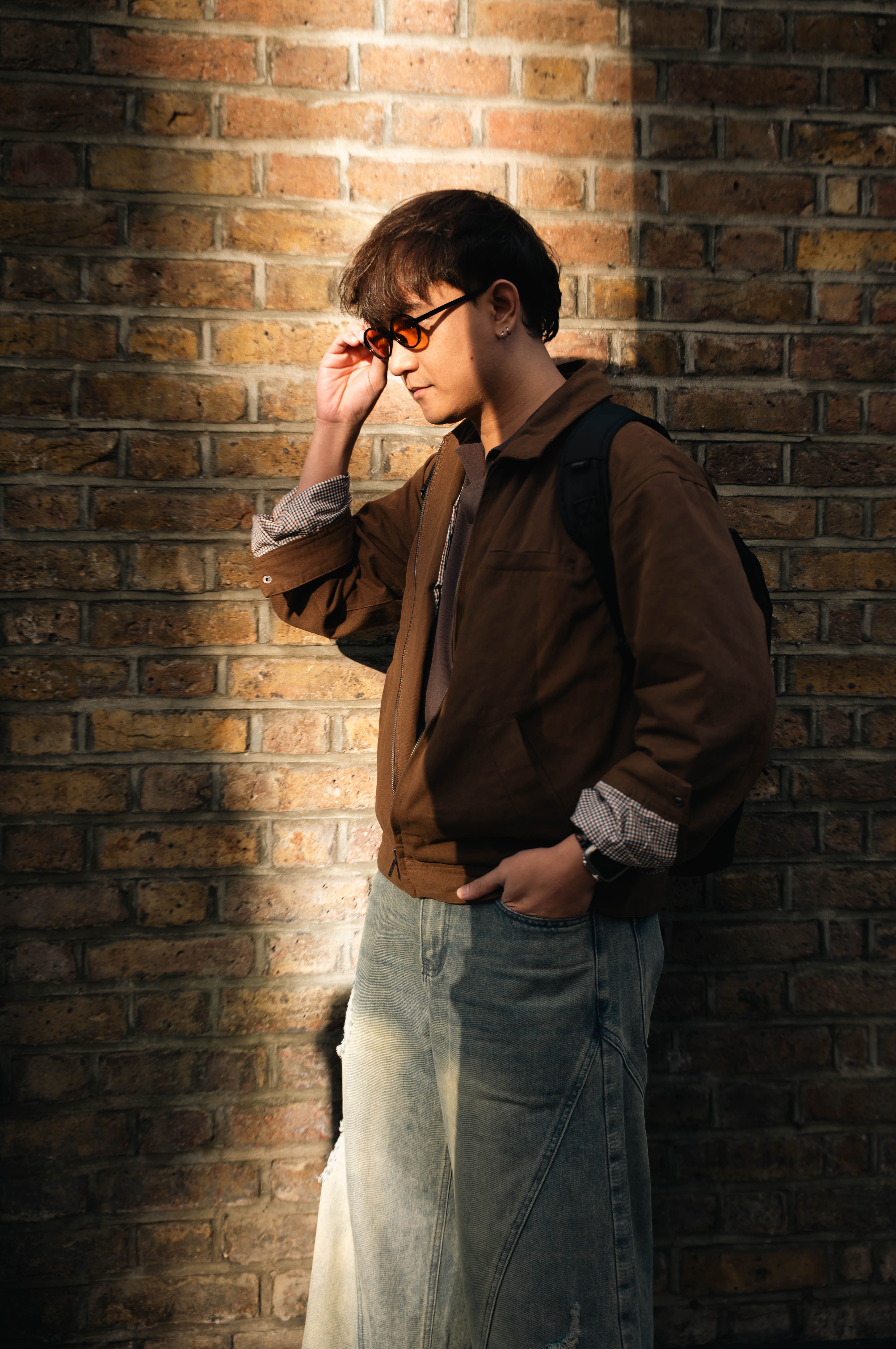 Man in Sunglasses Leaning Against Brick Wall · Free Stock Photo