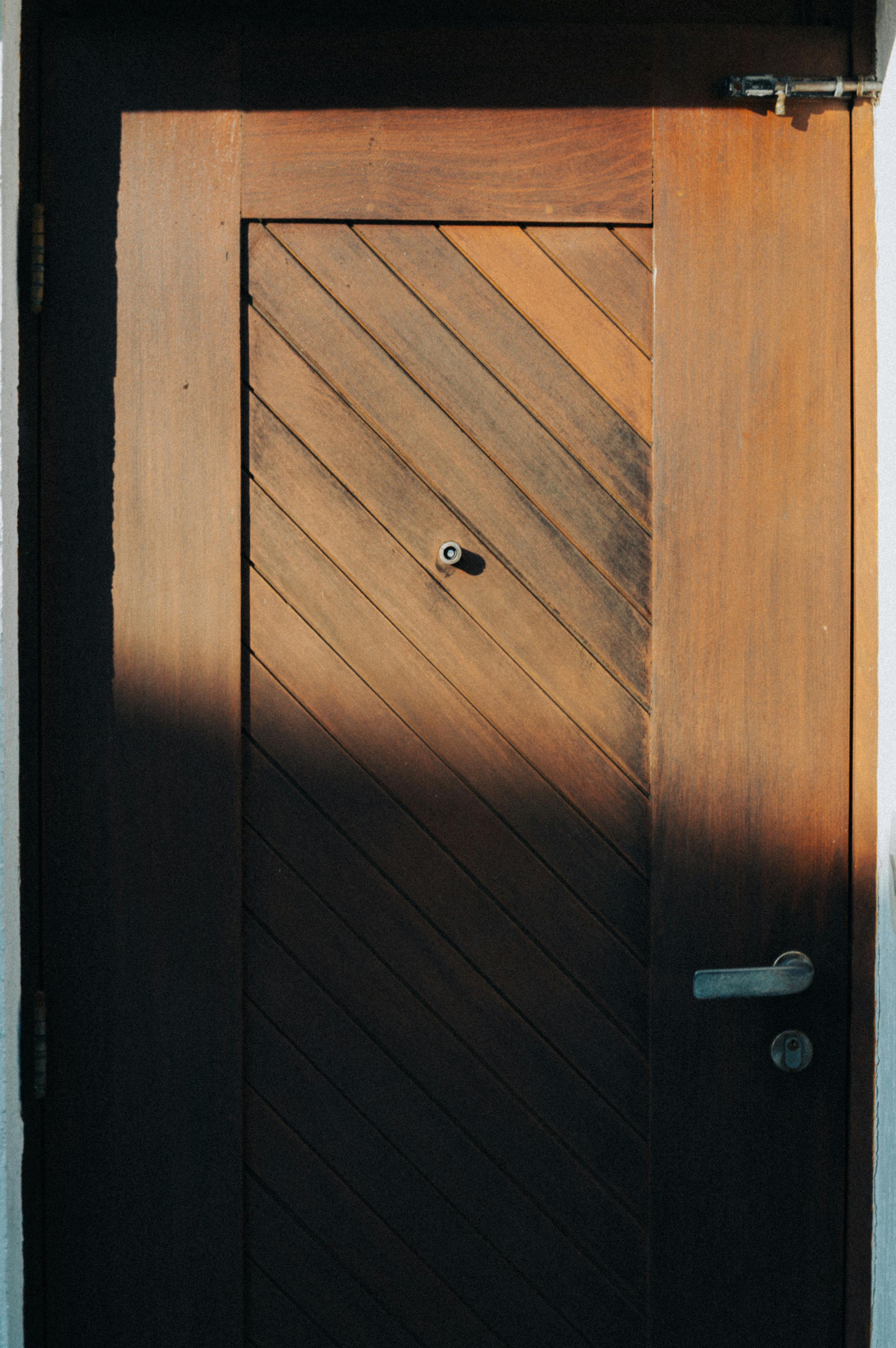 Δωρεάν Μια όμορφα κατασκευασμένη ξύλινη πόρτα με διαγώνιο σχέδιο στο φως του ήλιου. Φωτογραφία από στοκ φωτογραφιών