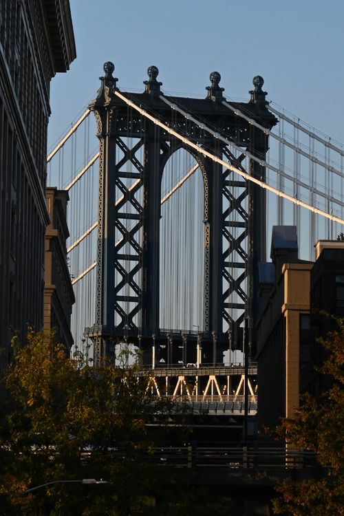 Free A classic view of the Manhattan Bridge framed by buildings, captured at dusk. Stock Photo