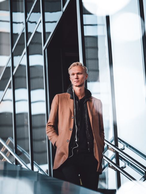 Portrait of a stylish young man in a city environment, captured outdoors on a bright day.