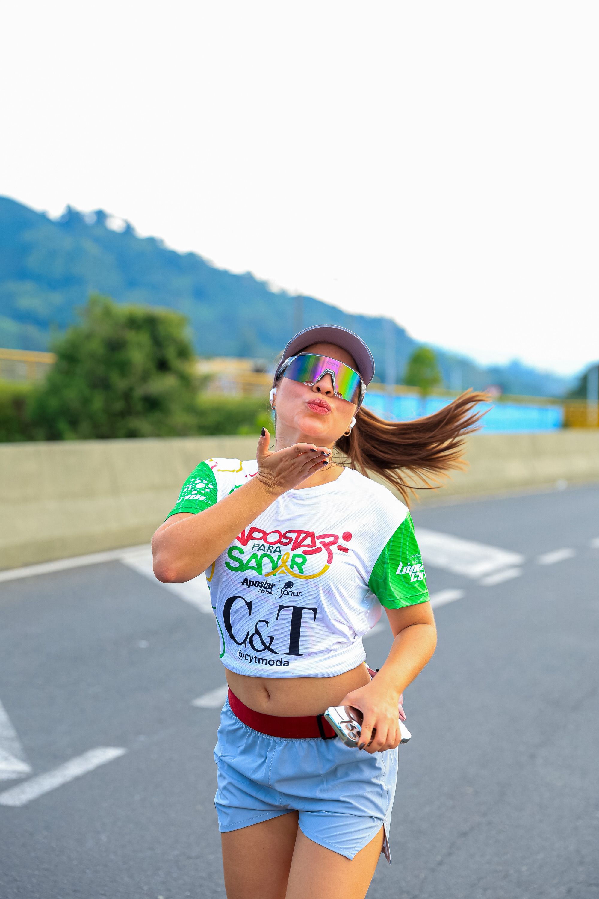 Energetic Runner Blowing a Kiss During Marathon · Free Stock Photo