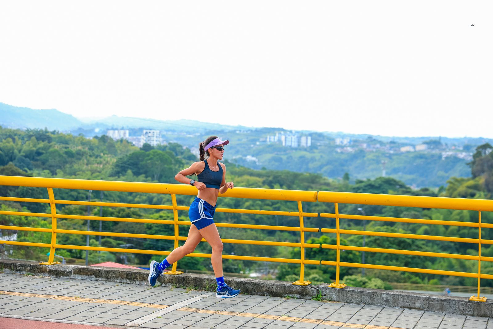 A woman running outdoors on a sunny path
